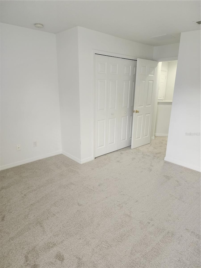 empty room with baseboards and light colored carpet