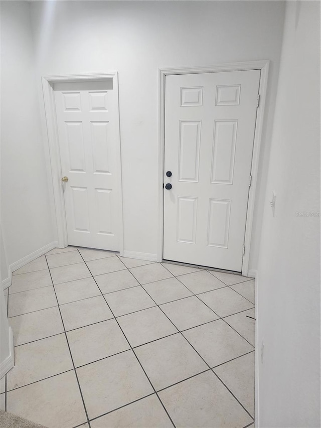 interior space featuring light tile patterned floors and baseboards