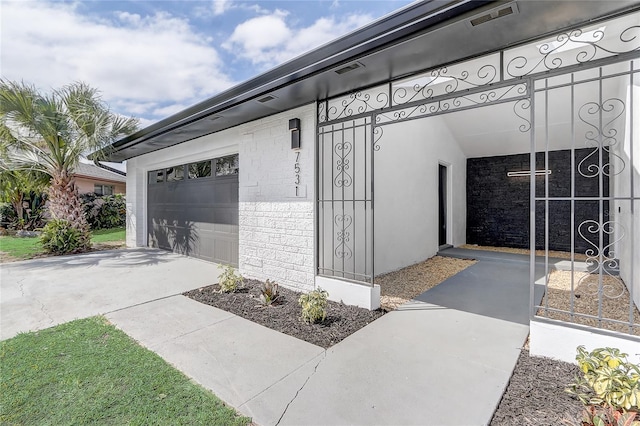 garage featuring concrete driveway and visible vents