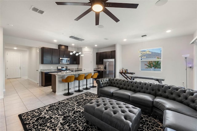 living area with light tile patterned floors, recessed lighting, visible vents, a ceiling fan, and baseboards