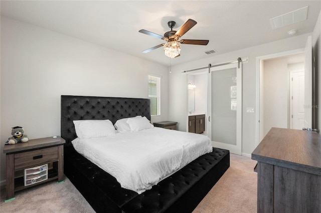 bedroom featuring light carpet, a barn door, visible vents, and ceiling fan