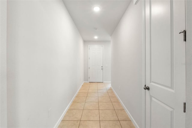 hall featuring recessed lighting, light tile patterned flooring, and baseboards