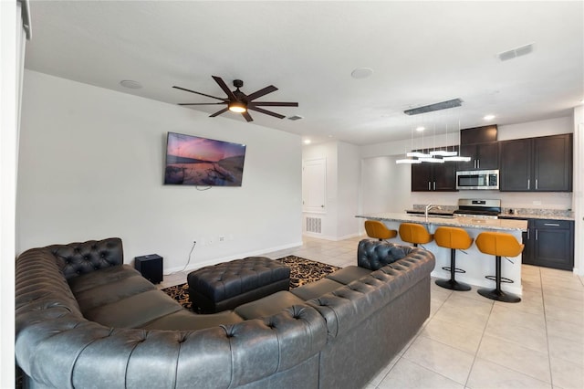 living room featuring visible vents, ceiling fan, baseboards, and light tile patterned floors