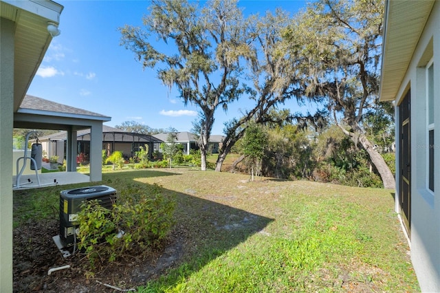 view of yard with a lanai and central AC