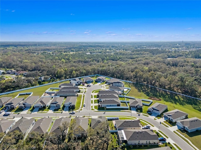 birds eye view of property with a residential view and a wooded view