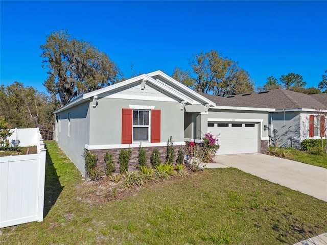 view of front of property featuring a garage, fence, stone siding, stucco siding, and a front lawn