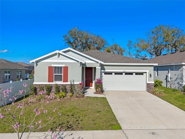 view of front facade with concrete driveway, an attached garage, fence, a front lawn, and stucco siding