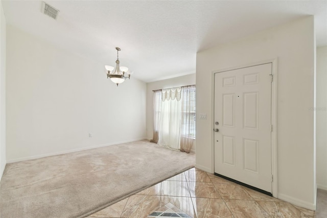 foyer entrance with light carpet, baseboards, visible vents, a textured ceiling, and a notable chandelier