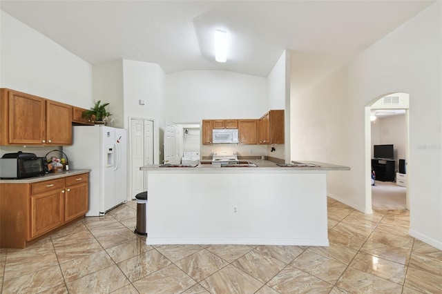 kitchen with white appliances, brown cabinets, and a peninsula