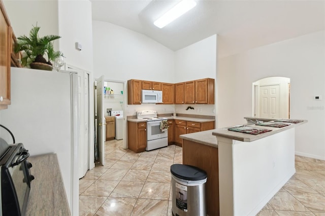 kitchen featuring high vaulted ceiling, white appliances, marble finish floor, light countertops, and brown cabinets