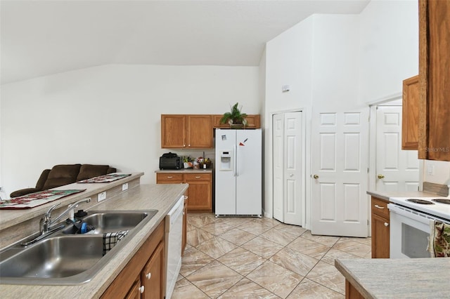 kitchen featuring white appliances, brown cabinets, light countertops, high vaulted ceiling, and a sink