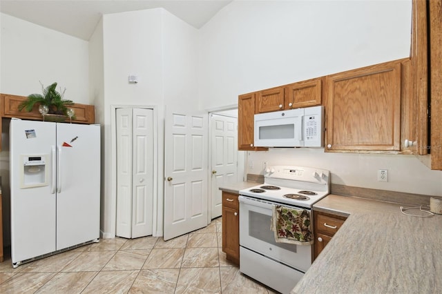 kitchen with brown cabinets, white appliances, a high ceiling, and light countertops