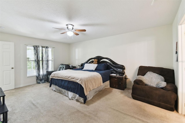 bedroom with a ceiling fan, light colored carpet, a textured ceiling, and baseboards