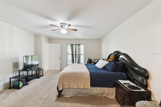 bedroom featuring a ceiling fan, light colored carpet, and a textured ceiling