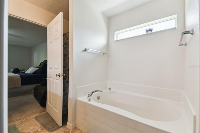 ensuite bathroom featuring tile patterned flooring, a garden tub, and ensuite bath