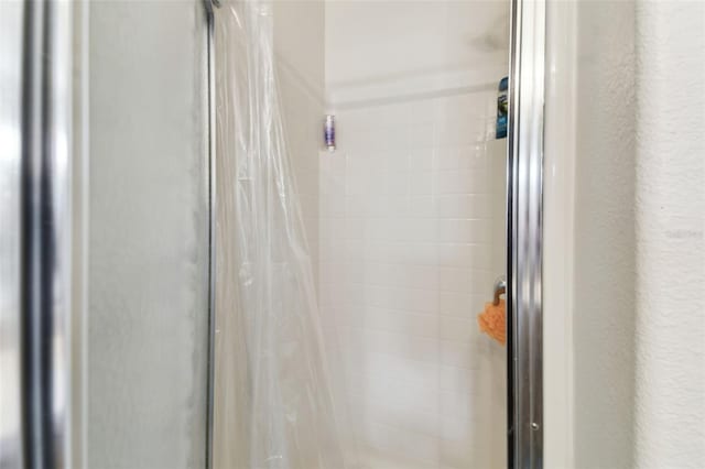 room details featuring a stall shower and a textured wall