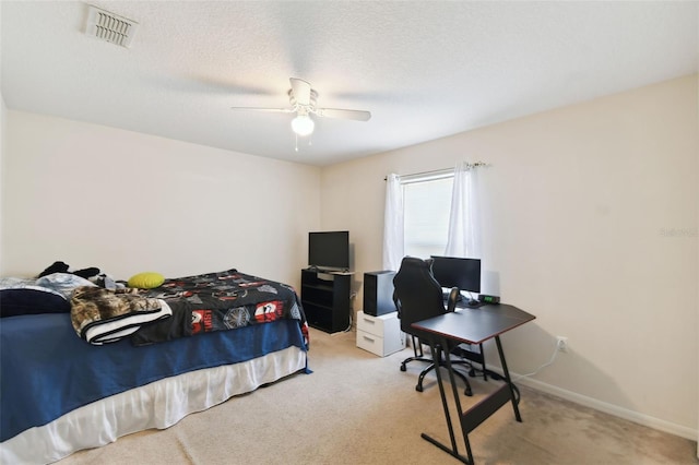 bedroom with baseboards, visible vents, light carpet, and a textured ceiling