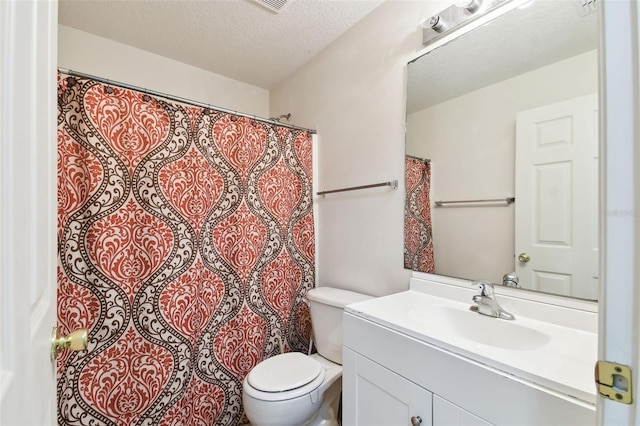 full bathroom with toilet, vanity, and a textured ceiling