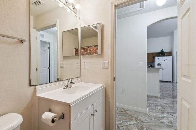 bathroom with baseboards, visible vents, toilet, marble finish floor, and vanity