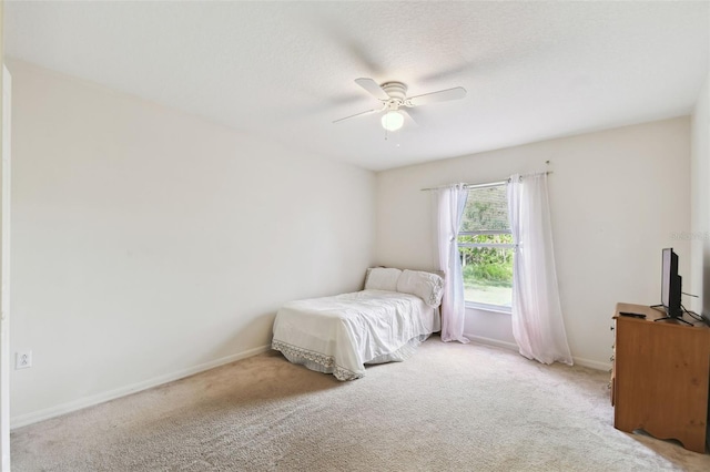 carpeted bedroom with a textured ceiling, a ceiling fan, and baseboards