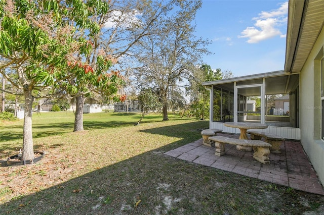 view of yard featuring a sunroom and a patio