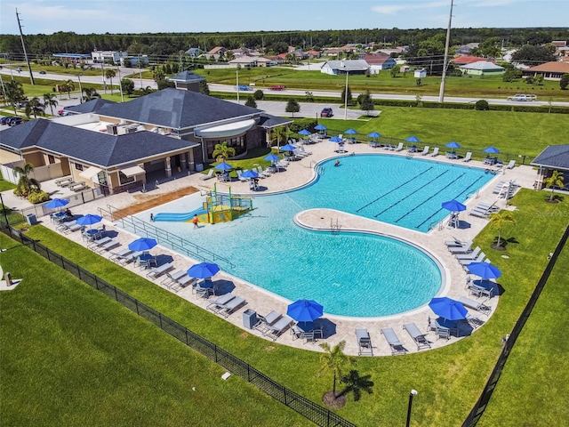 community pool featuring a yard, a patio area, and fence