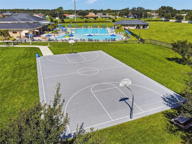 view of basketball court with community basketball court, fence, and a lawn