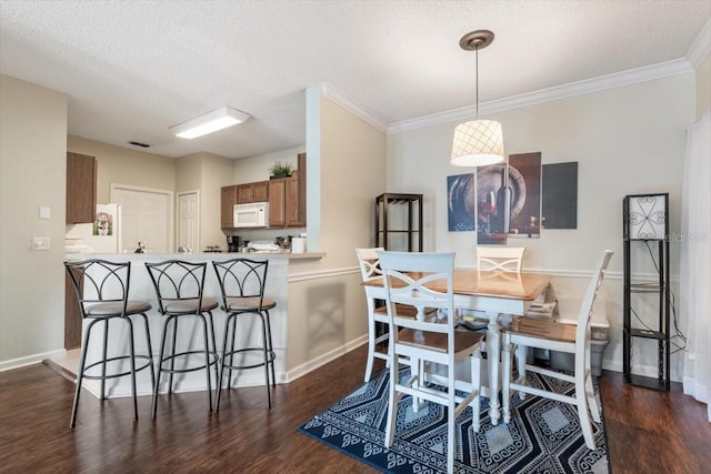 dining room with ornamental molding, dark wood finished floors, and baseboards