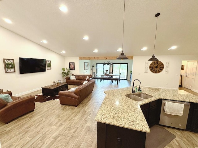 kitchen with dishwasher, light stone counters, open floor plan, hanging light fixtures, and a sink