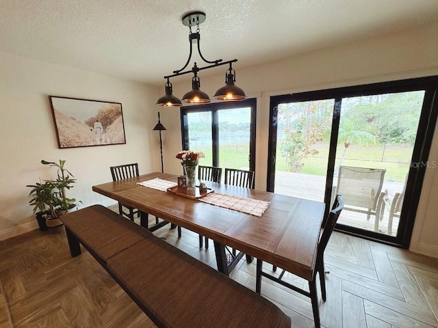 dining area with a textured ceiling and baseboards