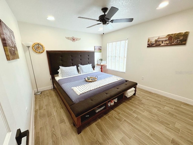 bedroom with baseboards, a ceiling fan, a textured ceiling, wood finish floors, and recessed lighting