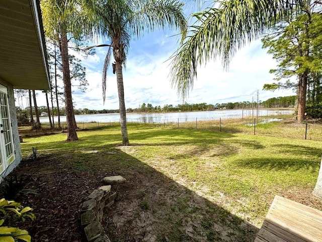 view of yard featuring a water view and fence