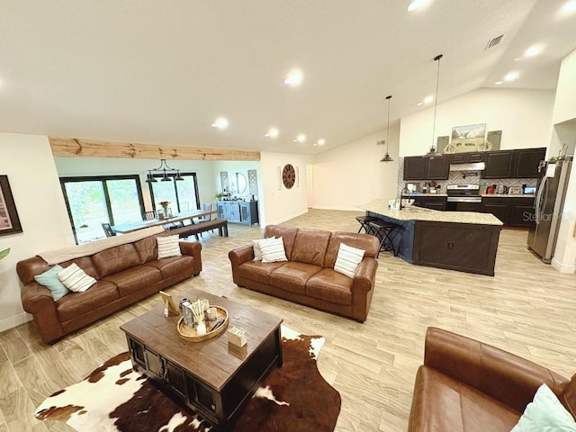 living area with light wood-type flooring, high vaulted ceiling, baseboards, and visible vents