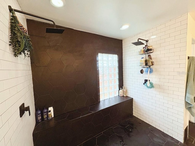 full bathroom featuring tiled shower, tile patterned flooring, and tile walls