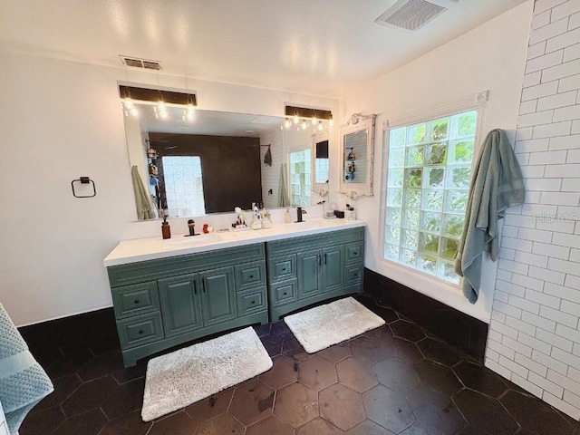 bathroom with tile patterned floors, visible vents, a sink, and double vanity