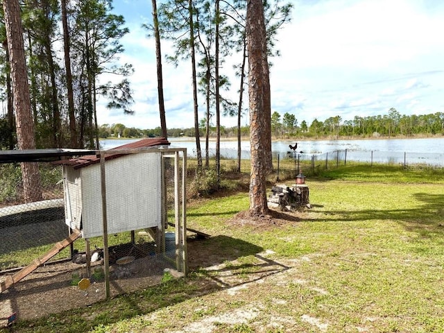 view of yard with an outbuilding, a water view, and exterior structure