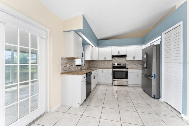 kitchen featuring dark stone counters, stainless steel appliances, a sink, and white cabinetry