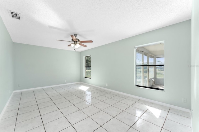 spare room with baseboards, a textured ceiling, visible vents, and a ceiling fan