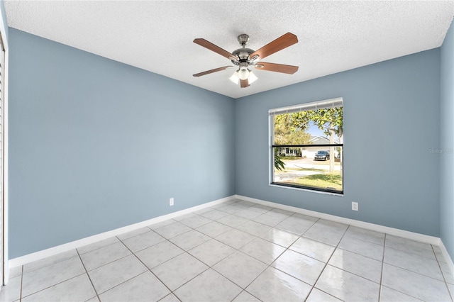 unfurnished room with ceiling fan, a textured ceiling, baseboards, and light tile patterned floors