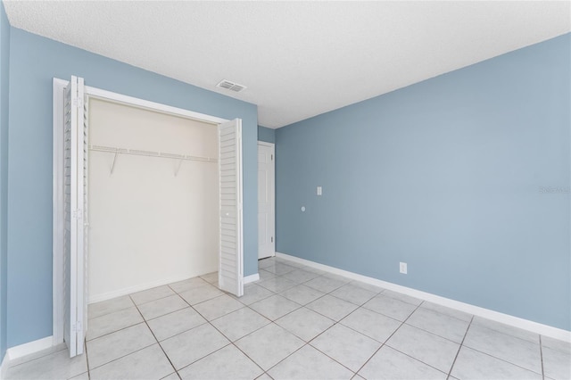 unfurnished bedroom featuring baseboards, a textured ceiling, visible vents, and a closet