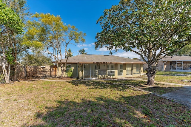 rear view of house featuring a yard and fence