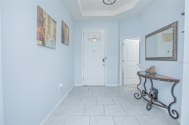 entrance foyer with baseboards and a raised ceiling