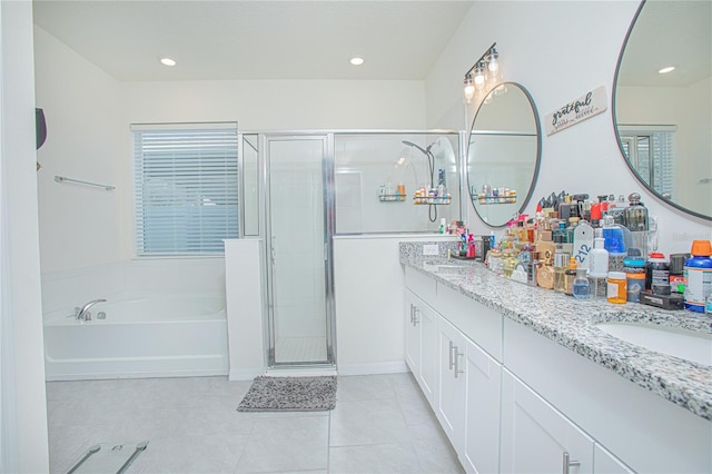 bathroom featuring a garden tub, double vanity, a sink, a shower stall, and tile patterned floors