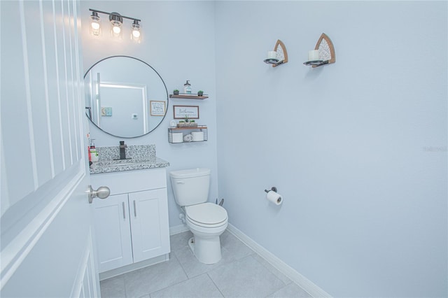 bathroom with tile patterned flooring, baseboards, vanity, and toilet