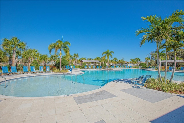 pool with a patio area and fence