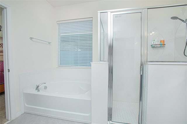 full bathroom featuring a stall shower, tile patterned flooring, a garden tub, and ensuite bathroom