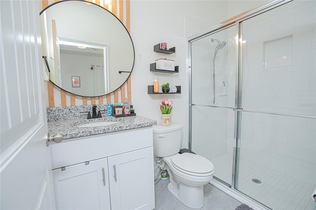 bathroom featuring toilet, a stall shower, and vanity