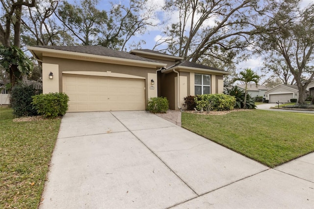 view of front of property with driveway, an attached garage, a front yard, and stucco siding