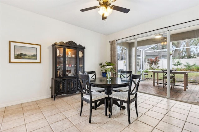 dining room with a ceiling fan, baseboards, and light tile patterned floors