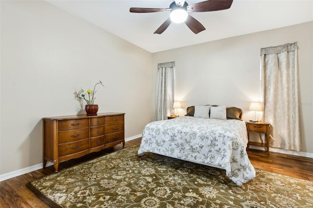 bedroom with vaulted ceiling, dark wood-style flooring, a ceiling fan, and baseboards